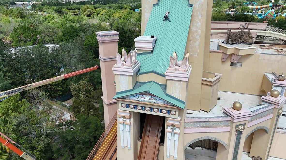 Roof work on a tall building with a turquoise roof